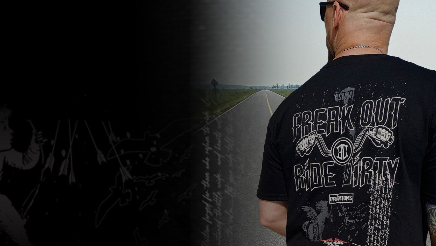 Man wearing a black t-shirt with graphic designs and text, standing on a road.